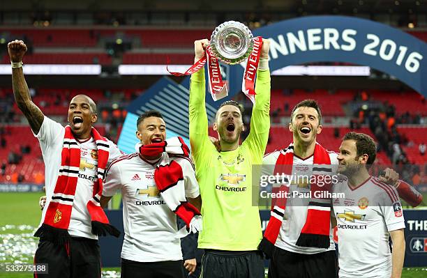 Ashley Young, Jesse Lingard, David De Gea, Michael Carrick and Juan Mata of Manchester United celebrate with the trophy on the pitch after The...