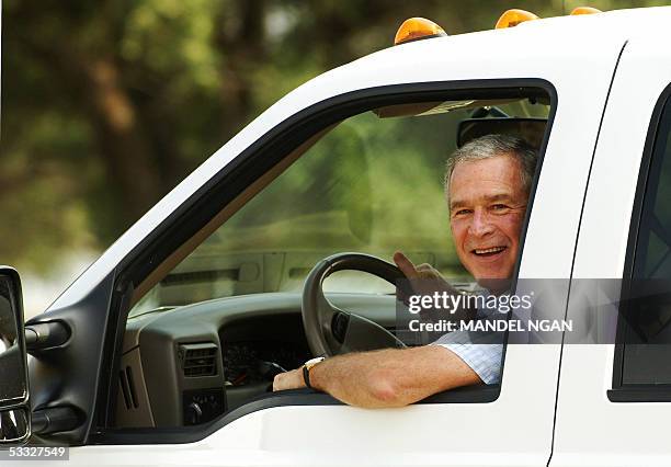 Crawford, UNITED STATES: US President George W. Bush drives in his pick-up with Colombian President Alvaro Uribe after he arrived on Bush's "Prairie...
