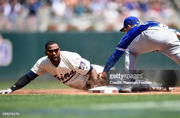 Darwin Barney of the Toronto Blue Jays tags out Eduardo Nunez of the Minnesota Twins at third base attempting to advance on a fly ball during the...
