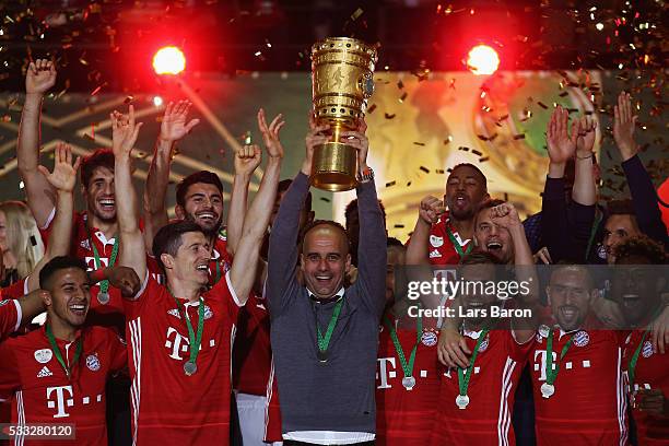 Head coach Pep Guardiola of Bayern Muenchen lifts the trophy after winning the DFB Cup final match in a penalty shootout against Borussia Dortmund at...