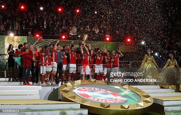 Bayern Munich's Spanish head coach Pep Guardiola and Bayern Munich's players celebrate with the trophy during the winners ceremony after winning the...