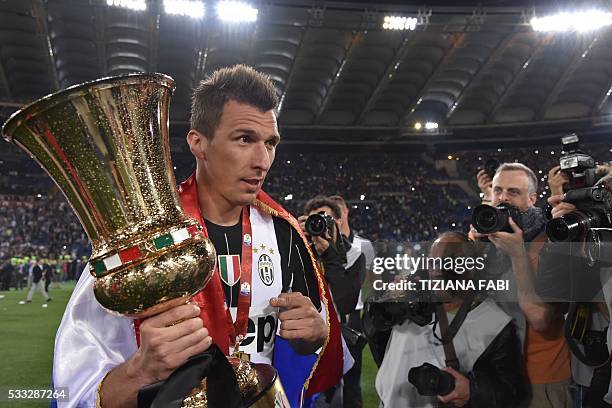 Juventus' forward from Croatia Mario Mandzukic celebrates with the trophy after winning the Italian Tim Cup final football match AC Milan vs Juventus...