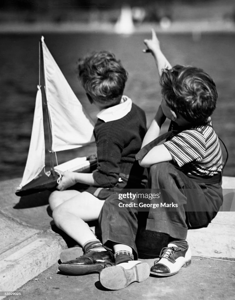 Two boys playing w/sailboats