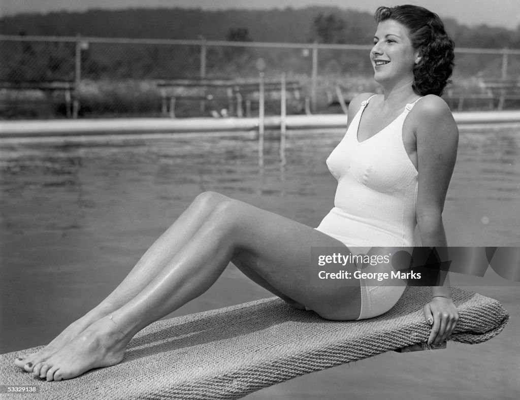 Woman sitting on divingboard