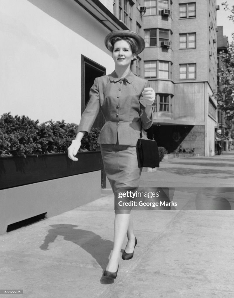 Woman walking down sidewalk