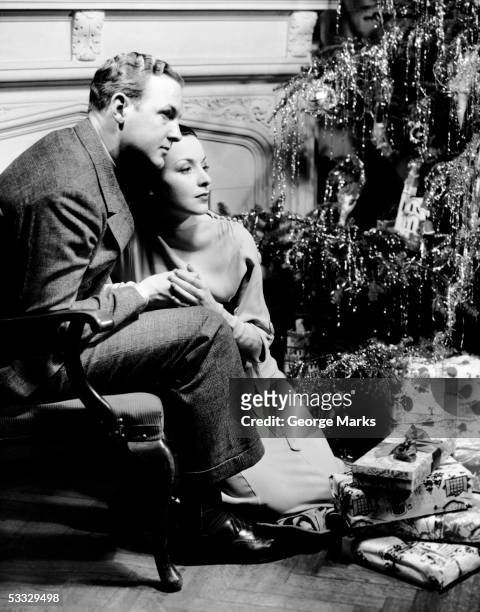 couple looking at christmas tree - christmas tree 50's stock pictures, royalty-free photos & images