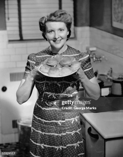 woman holding out plate of biscuits - 1950 woman bildbanksfoton och bilder