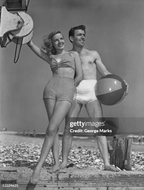 couple on beach w/beach ball - 1950s beach ball stock pictures, royalty-free photos & images