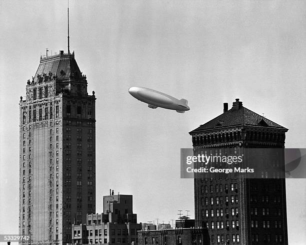 blimp over city - luftschiff stock-fotos und bilder