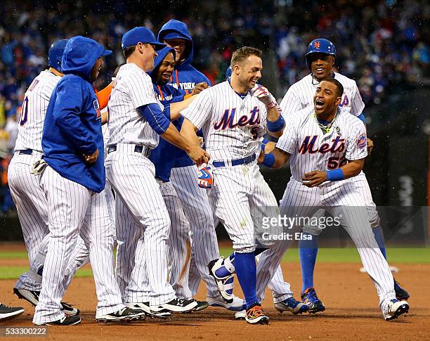 David Wright of the New York Mets is congratulated by Yoenis Cespedes and the rest of his teammates after Wright hit a walk off single to win the...
