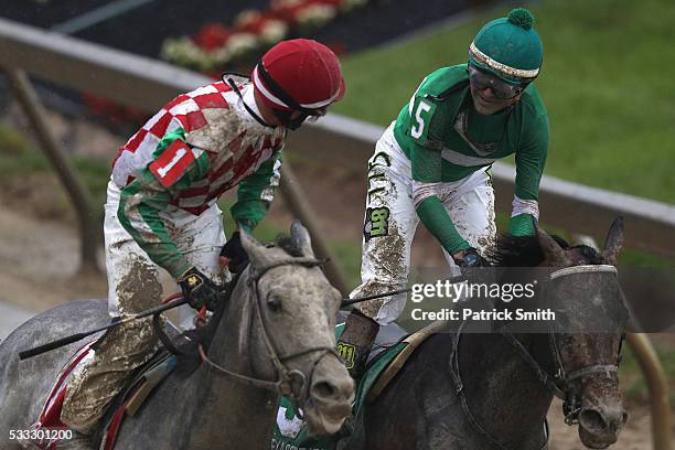 Jockey Corey Lanerie of Cherry Wine celebrates with jockey Kent Desormeaux of Exaggerator after Exaggerator crossed the finish line to win the 141st...