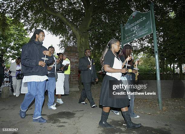 People participate in a candlelit procession from St.Gabriel's church in Hall Lane to McGoldrick Park to pay their respects at the scene of the...
