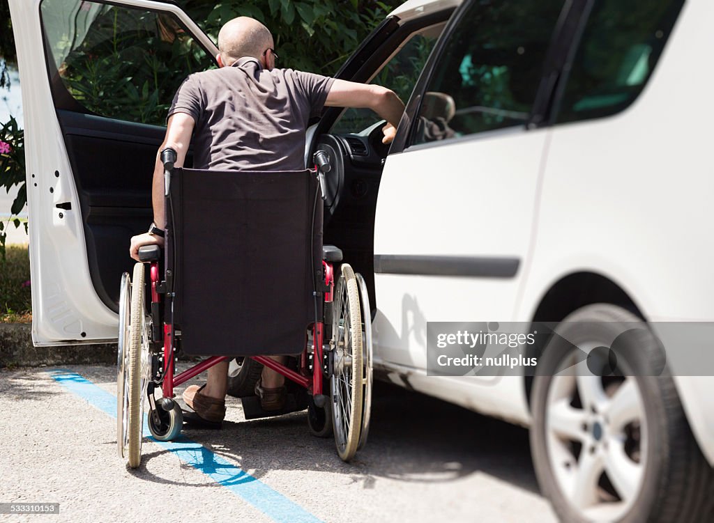 Erwachsener Fahrer im Rollstuhl sich in das Fahrzeug