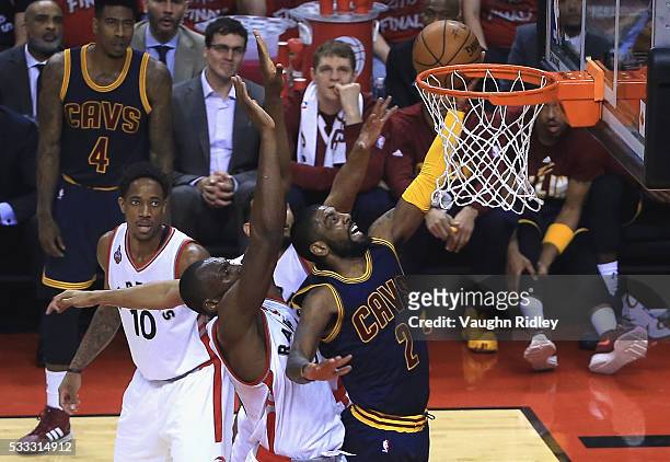 Kyrie Irving of the Cleveland Cavaliers shoots the ball against Bismack Biyombo of the Toronto Raptors during the first half in game three of the...
