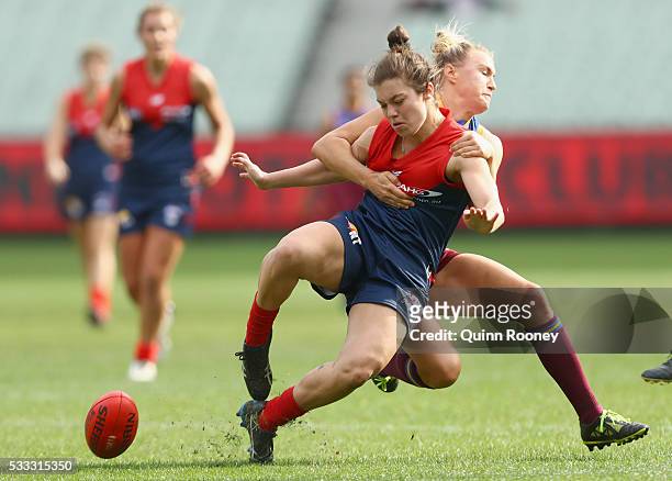 Ellie Blackburn of Melbourne kicks whilst being tackled by Selina Goodman of Queensland during the women's AFL exhibition match between Melbourne and...