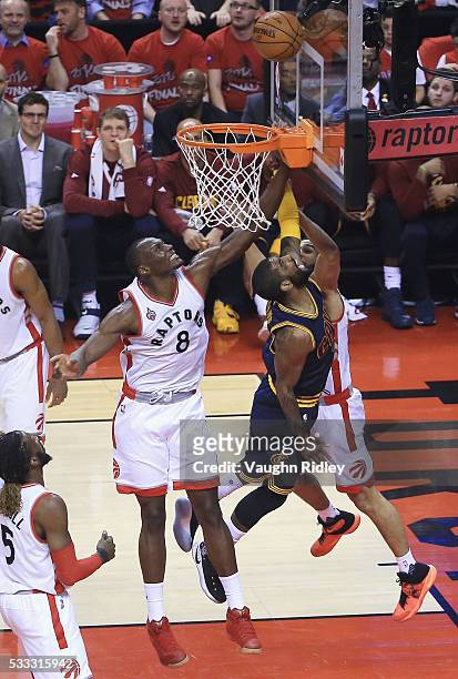 Kyrie Irving of the Cleveland Cavaliers shoots the ball against Bismack Biyombo of the Toronto Raptors and Cory Joseph during the first half in game...