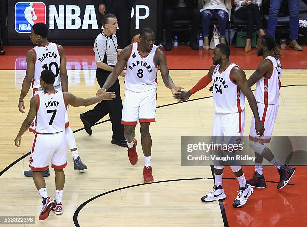 Bismack Biyombo of the Toronto Raptors high fives teammates during the second half against the Cleveland Cavaliers in game three of the Eastern...