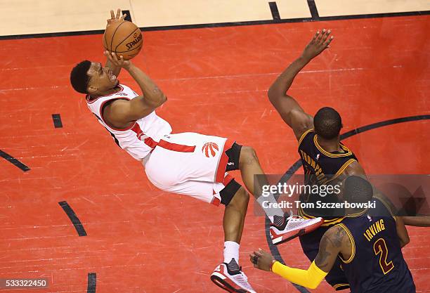 Kyle Lowry of the Toronto Raptors shoots the ball as he falls during the second half against the Cleveland Cavaliers in game three of the Eastern...