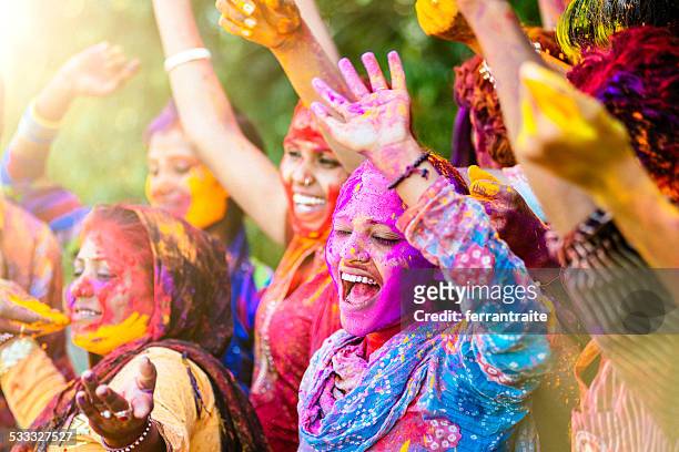 indian women throwing colored holi powder - holi phagwa stockfoto's en -beelden