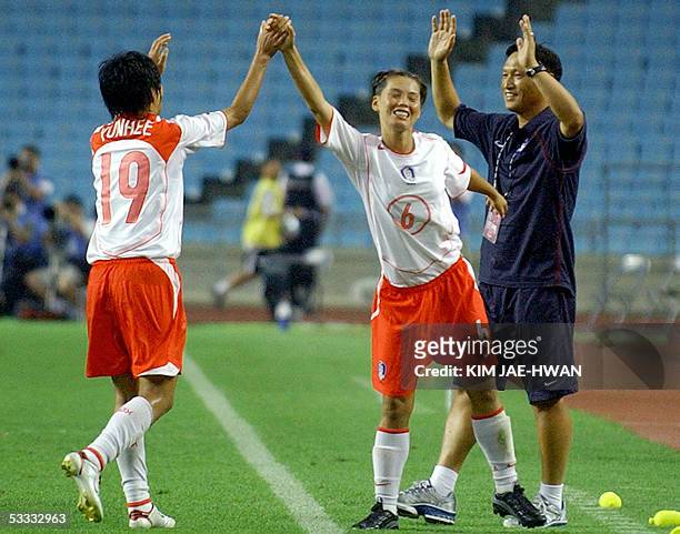 South Korean Jin Suk-Hee celebrates with her teammate Cha Yun-Hee after their victory over Japan in the East Asian Football Federation Women's Cup in...