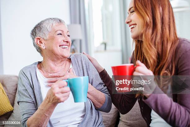 mother and dauther having hot drinks together - grandma daughter stock pictures, royalty-free photos & images