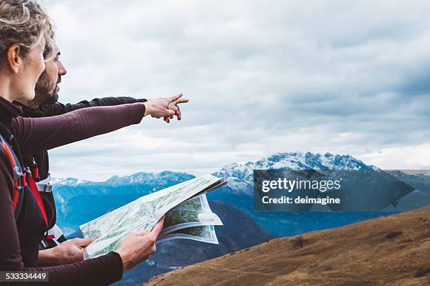 hiking couple with map in mountain - navigatieapparatuur stockfoto's en -beelden