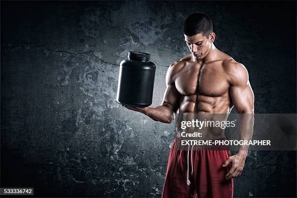 strongman with can of supplements - bodybuilder posing stock pictures, royalty-free photos & images