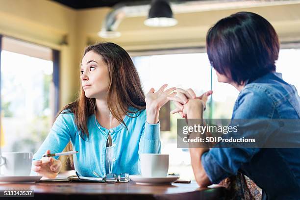 molesto teen girl talking a la madre en la cafetería - emoción negativa fotografías e imágenes de stock