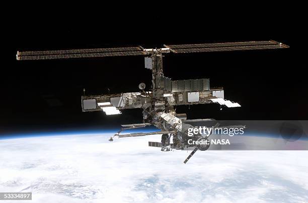 In this NASA handout, back dropped by the blackness of space and Earth?s horizon, this full view of the International Space Station is seen onboard...