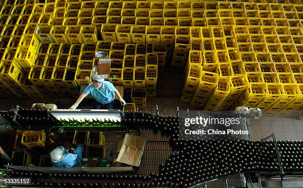 Woman works at the beer production line in Guangzhou Zhujiang Beer Group Company factory on August 6, 2005 in Guangzhou of Guangdong Province, South...