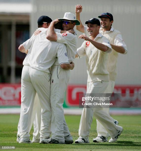 Andrew Flintoff of England is congratulated by his team mates after taking the wicket of Shane Warne of Australia during day four of the second...