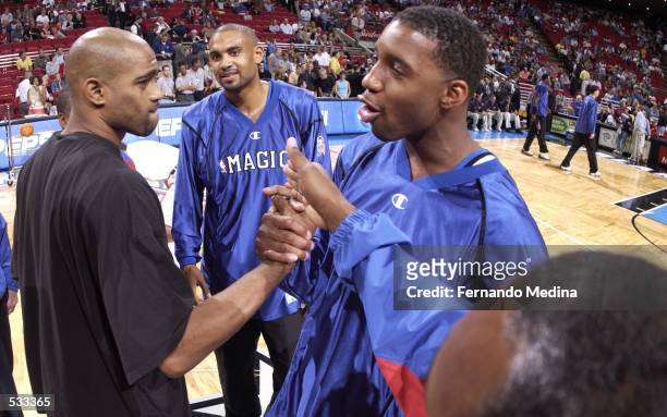 Tracy McGrady and Grant Hill of the Orlando Magic shakes hands with Vince Carter of the Toronto Raptors before the NBA game at the TD Waterhouse...