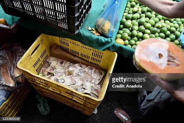 Vegetables container used to put a large amount of bills of the sales of days in a local market in Caracas, Venezuela on May 21, 201. Venezuelans...