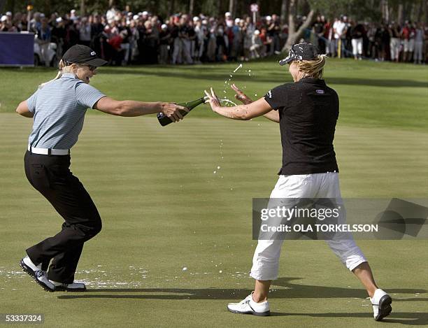 Swedish golfer Annika Sorenstam is chased with champagne by her sister Charlotta Sorenstam after winning the Scandinavian TPC golf tournament at the...