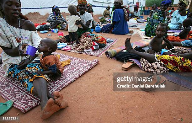 Mothers feed their children at an MSF clinic August 7, 2005 in Aguie, Niger. These clinics, though few in number, are providing vital care and aid to...