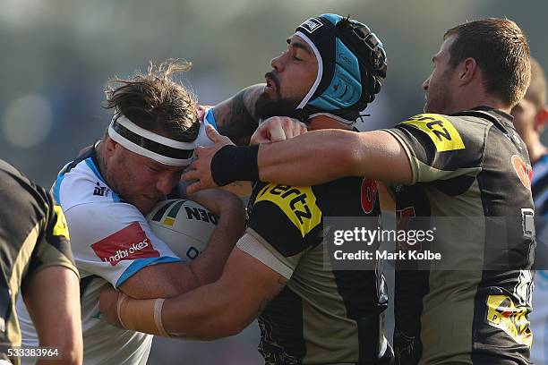 Chris McQueen of the Titans is tackled by Jamie Soward and Trent Merrin of the Panthers during the round 11 NRL match between the Penrith Panthers...