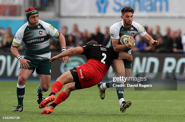 Owen Williams of Leicester is tackled by Schalk Brits during the Aviva Premiership semi final match between Saracens and Leicester Tigers at Allianz...