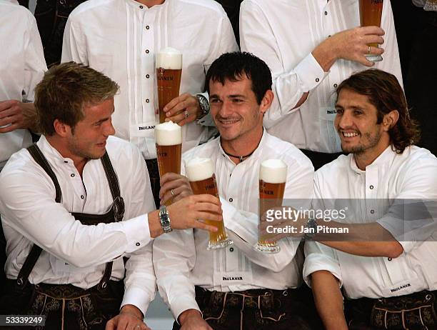 Michael Rensing, L, Willy Sagnol, C, and Bixente Lizarazu, R, cheer with beers during a photo session of Bayern Munich on August 8, 2005 in Munich,...