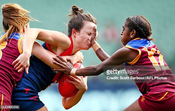 Daisy Pearce of Melbourne is tackled by Emily Bates of Brisbane and Delma Gisu of Brisbane during the 2016 AFL Womens match between the Melbourne...