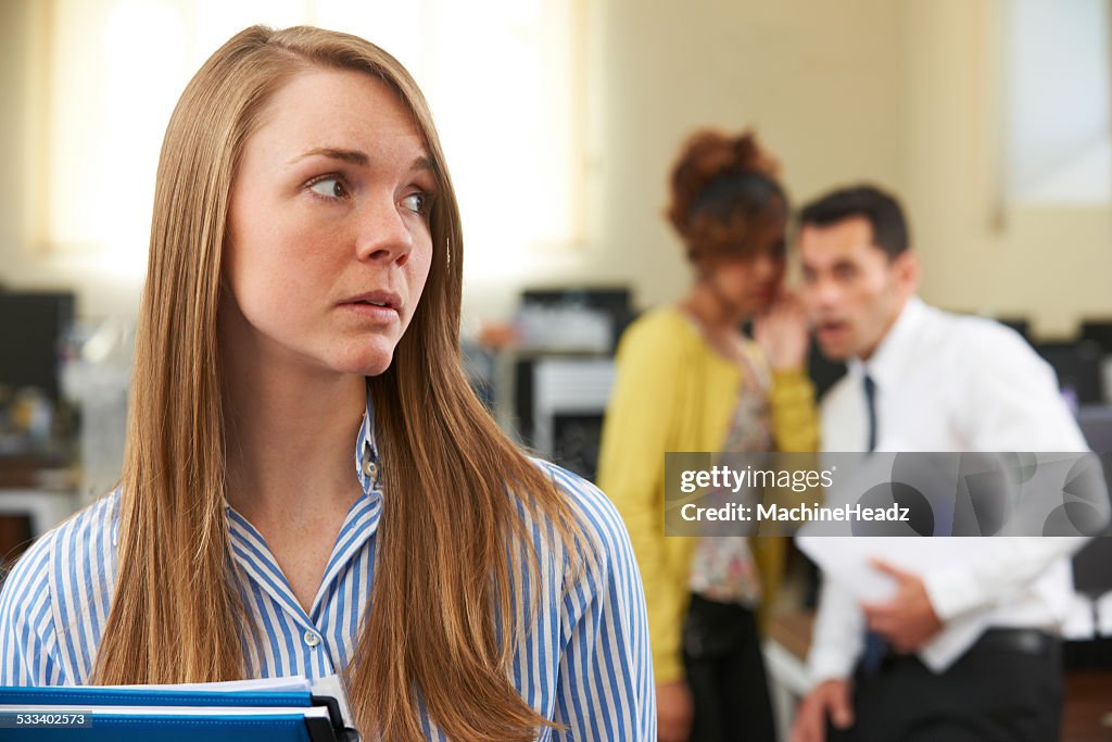 Mulher de Negócios sendo Gossiped sobre pelos colegas no escritório