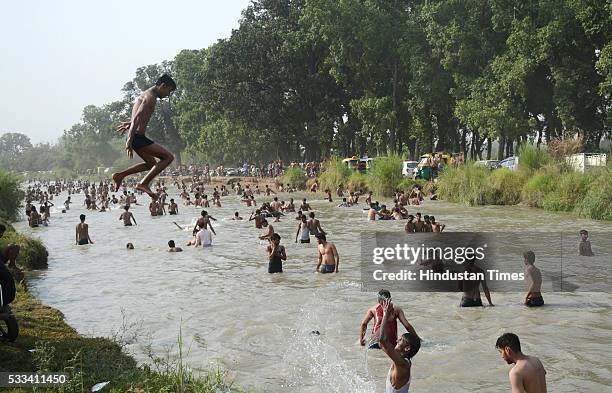 Children enjoy a swimming in Masuri River as Delhi/NCR experienced yet another scorching day, on May 22, 2016 in Ghaziabad, India. Heat waves hit...