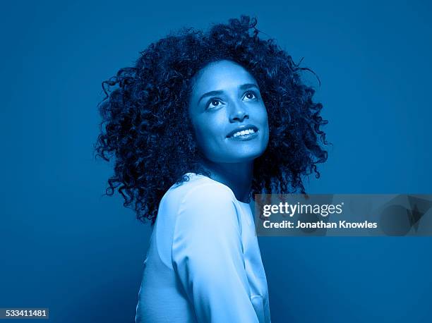 dark skinned female looking up, smiling - blue blouse stock pictures, royalty-free photos & images