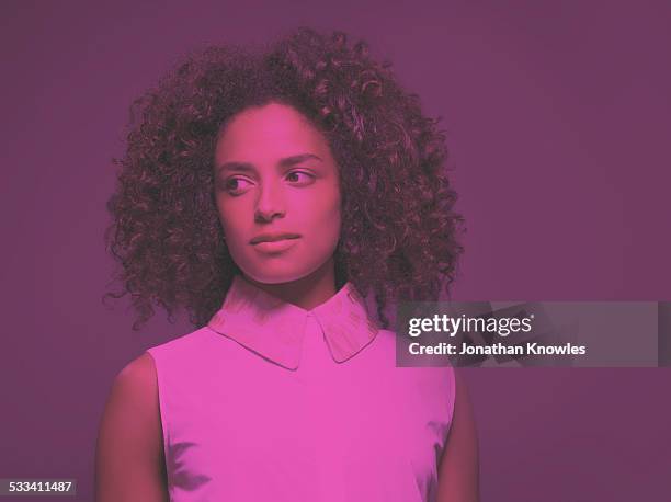 dark skinned female looking away - purple shirt stock-fotos und bilder