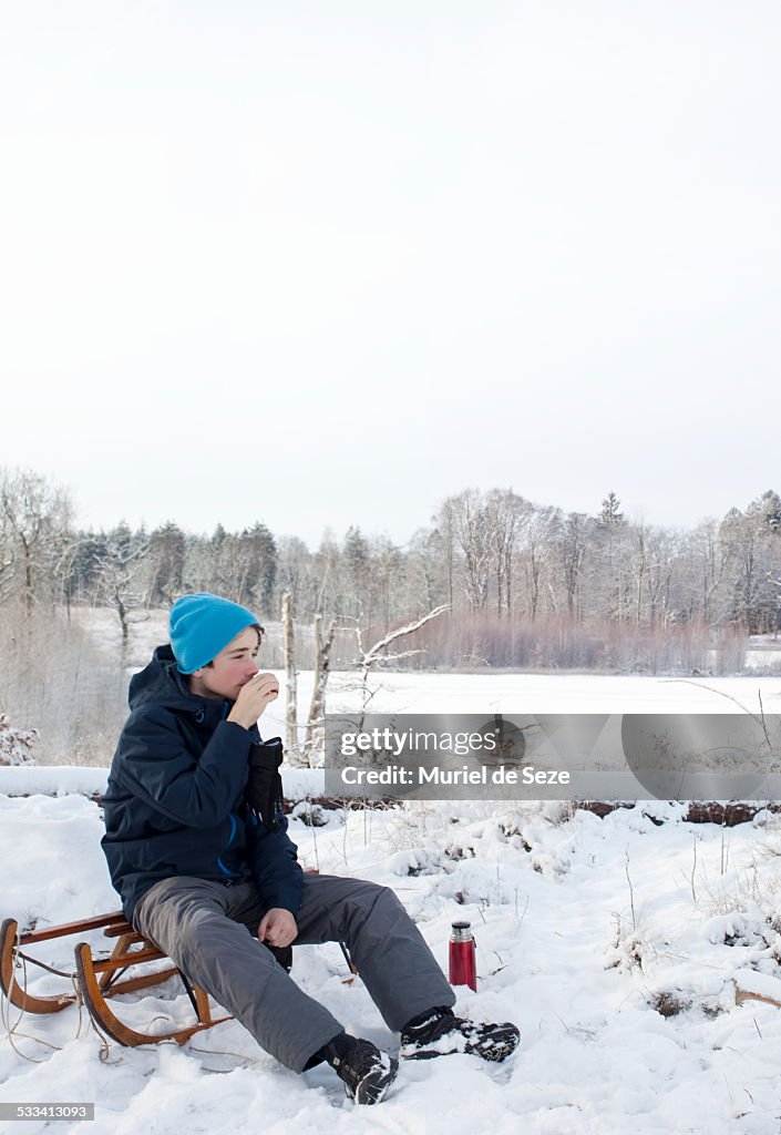 Boy with sledge in snowy landscape