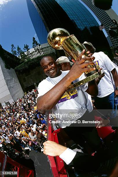 Shaquille O'Neal of the Los Angeles Lakers holds the NBA Championship Trophy during a parade after winning the 2000 NBA Finals against the Indiana...
