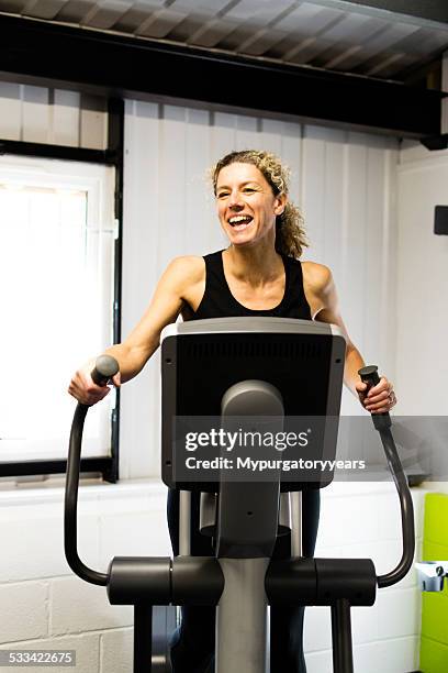 laughing in the gym - happy caucasian woman on elliptical trainer at gym stock pictures, royalty-free photos & images