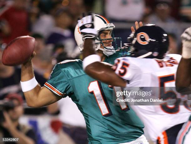 Quarterback Gus Frerotte of the Miami Dolphins tries to throw under pressure from linebacker Lance Briggs of the Chicago Bears during the NFL Hall of...