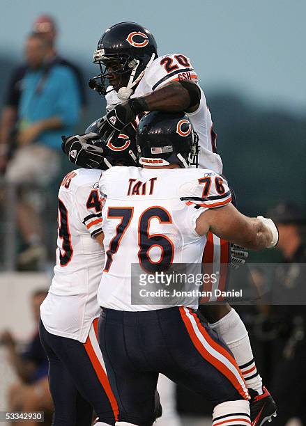 Running back Thomas Jones of the Chicago Bears is lifted by teammates John Tait and Jack Hunt after scoring a touchdown against the Miami Dolphins...