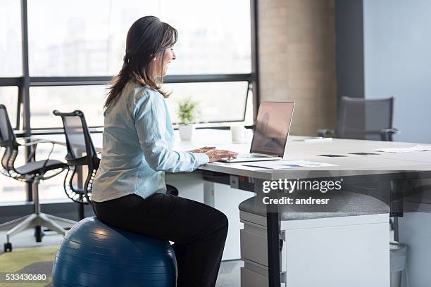 business woman exercising at the office - exercise ball stock pictures, royalty-free photos & images