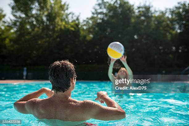 jóvenes amigos mientras juegan en la piscina - volear fotografías e imágenes de stock